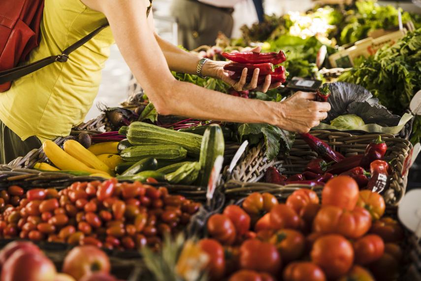 man-choosing-vegetable-from-vegetable-stall-at-supermarket